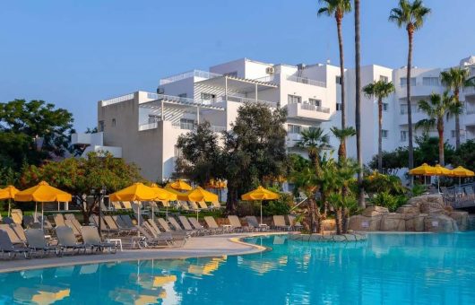 Outdoor pool with yellow umbrellas at Mayfair Hotel & Gardens for holidays in Paphos